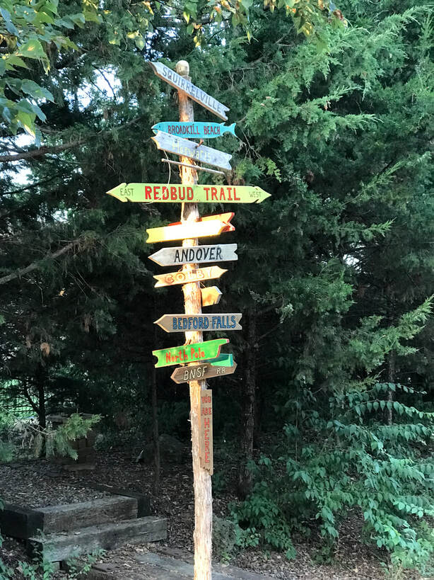 Color photo of a rustic signpost.  Photo by Lynne Schall, author, September 2022.